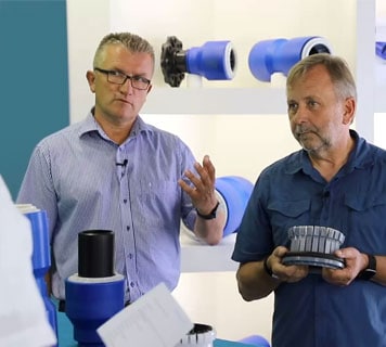 Zwei Männer erklären PE Formteilprodukte für den Kunststoff Rohrleitungsbau